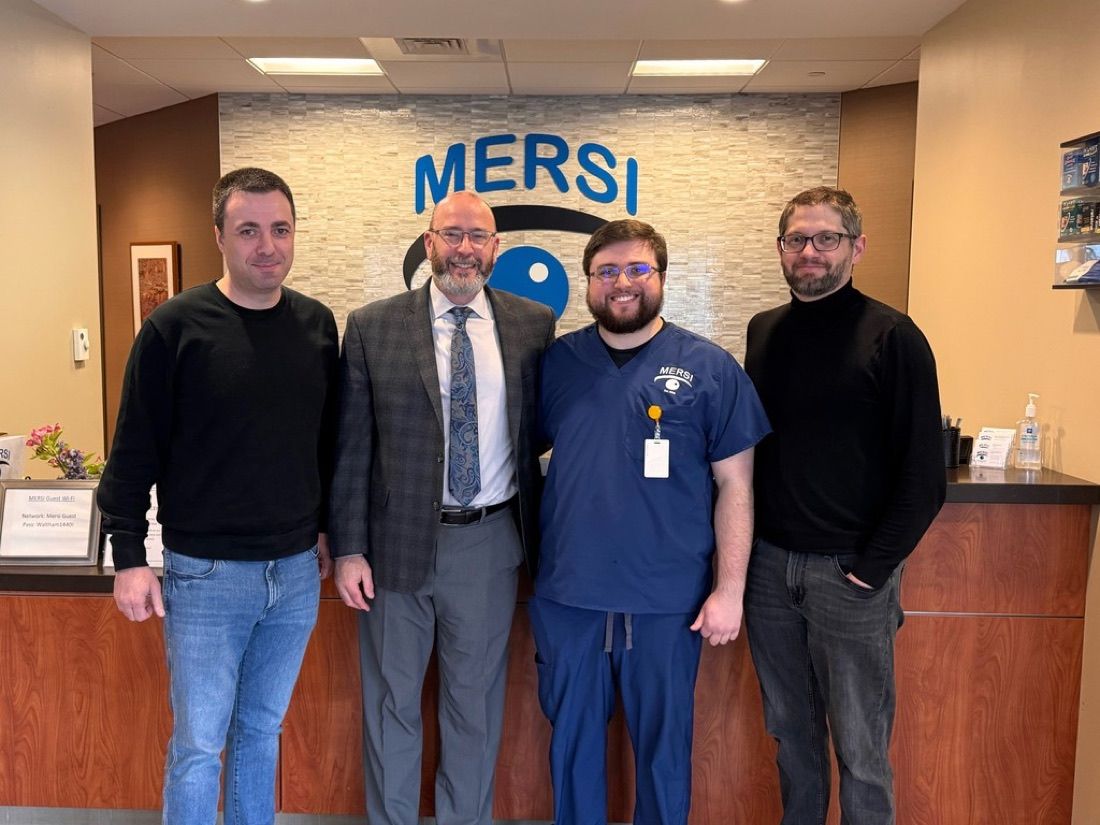 Four members of the MERSI and Carethink teams in front of the MERSI sign